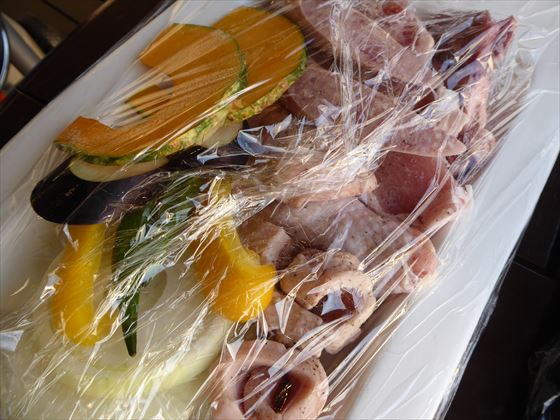 皿にのってラップされた久米島で収穫された野菜、久米島名産の鶏肉、豚肉、牛肉、ソーセージ