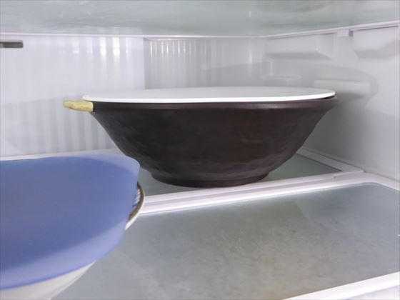 皿で蓋をして冷蔵庫に入れている様子