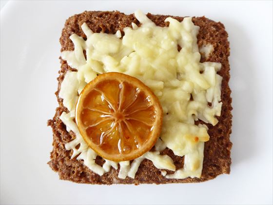 茶色いオールブランミニ食パン風にチーズと輪切りのレモンがのっている様子