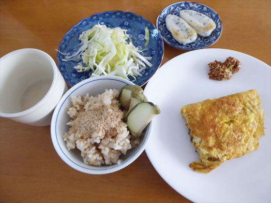 白い皿にオムレツと粒マスタード、茶碗に玄米とぬか漬け、小皿に笹かまぼこ