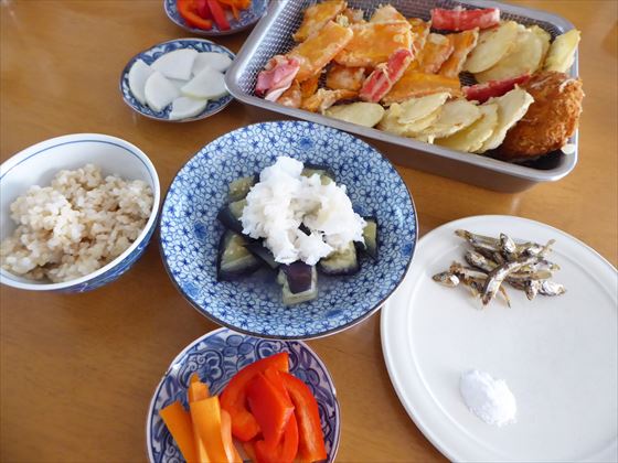 バットに入った天ぷらや青い皿に盛った蒸しナスに大根おろし