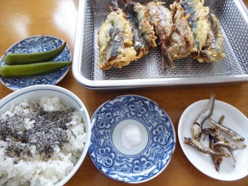 バットに並んだイワシの天ぷらや、小皿にオクラのぬか漬けや田作りなど